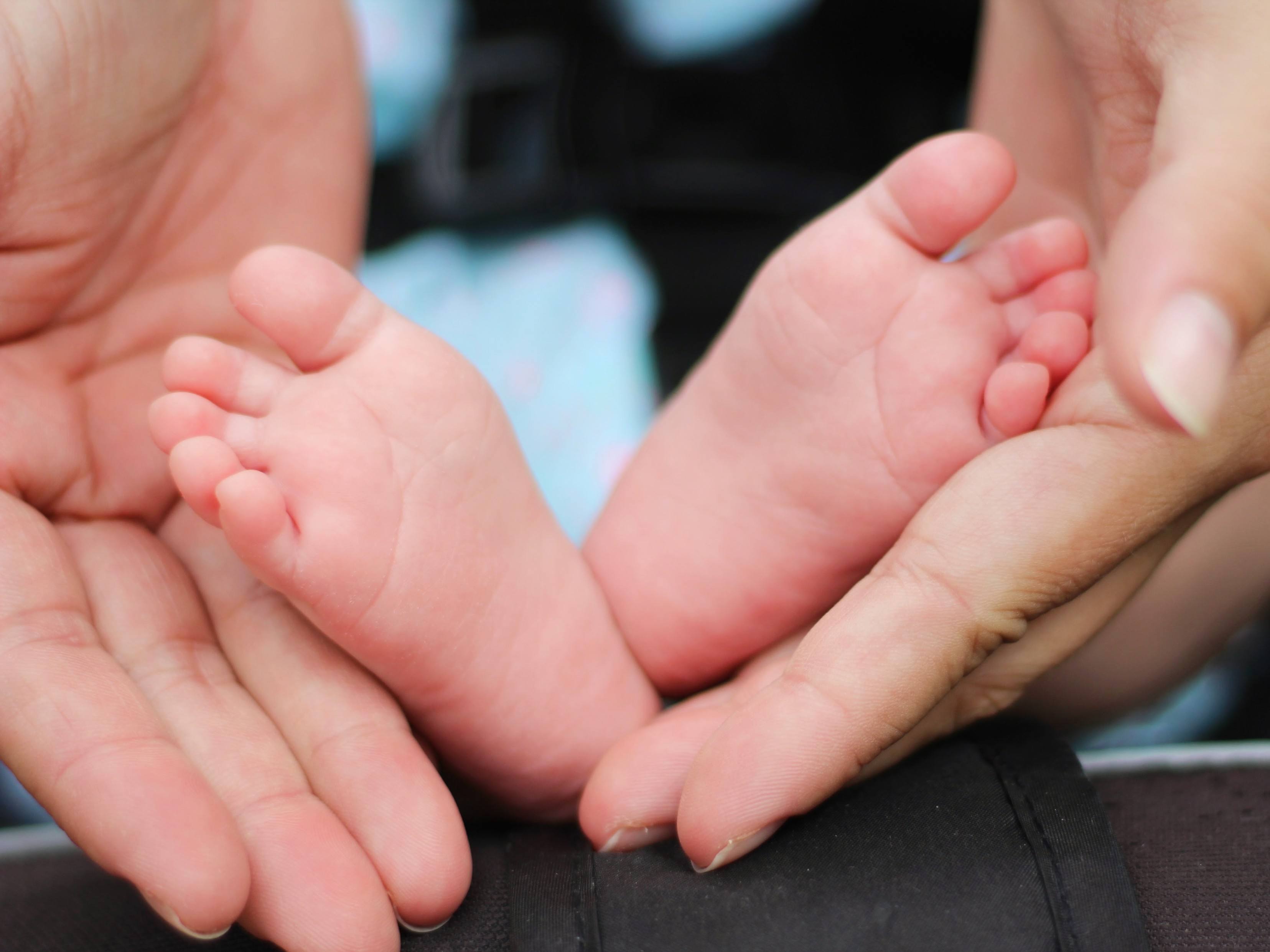 Child's feet in mother's hands